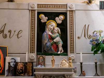 ...e decorato con statuette, candele e immagini sacre